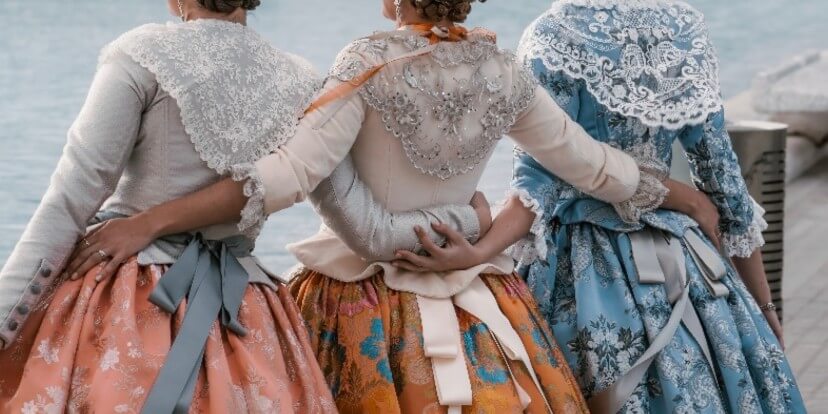 three women wearing beautiful dresses