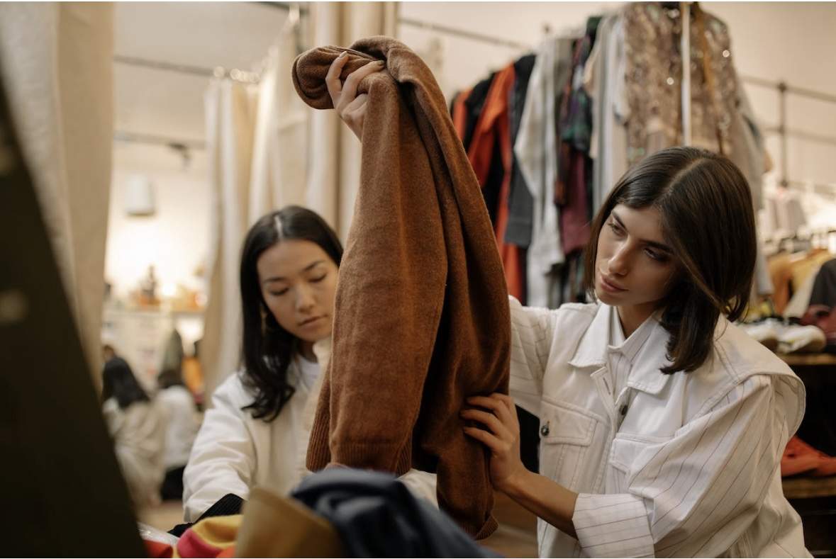 Two women picking out vintage fashion pieces.
